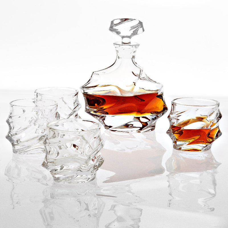 A crystal decanter set with a large decanter bottle and four whiskey glasses, filled with what appears to be whiskey.