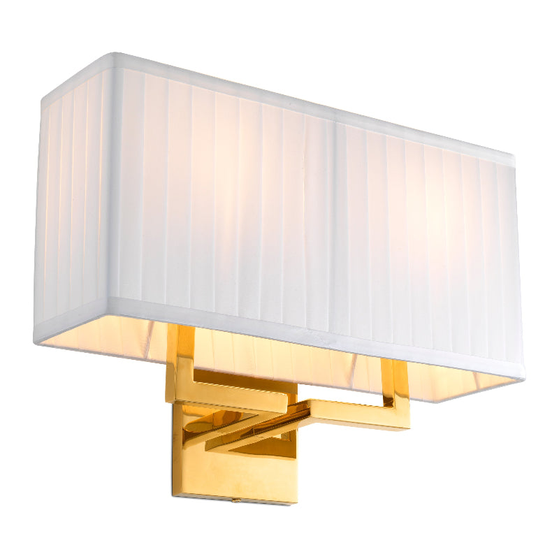A contemporary style wall lamp with a gold finish wall bracket and a pleated white lampshade.