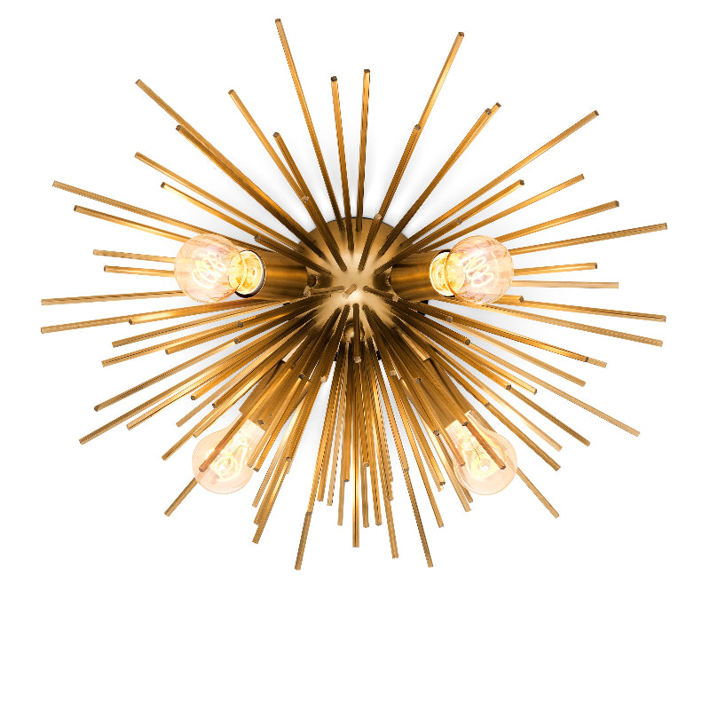 A gold-colored ceiling lamp with a starburst shape and multiple lights, featuring a matte brass finish.